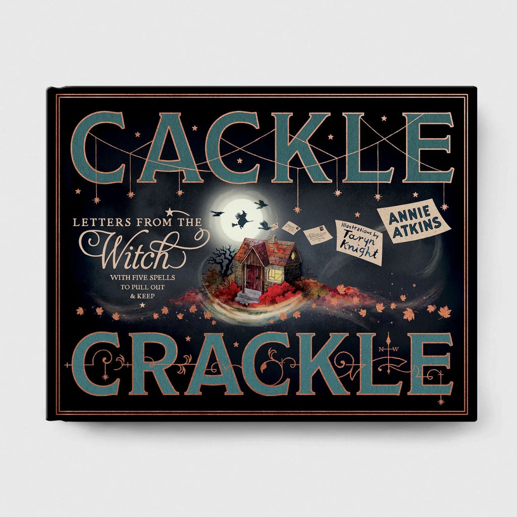 A square decorative book or box cover titled 'Cackle Crackle' with whimsical illustrated artwork, including a small cottage, bats, letters, and autumn leaves on a dark background. The text 'Letters from the Witch with four skills to pull out a heap' and 'Annie Atkins' are visible.