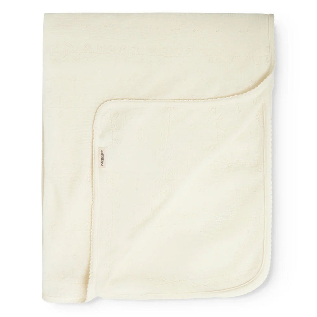 A folded cream-colored cotton blanket with a soft, plush fleece reverse side, shown on a clean white background.