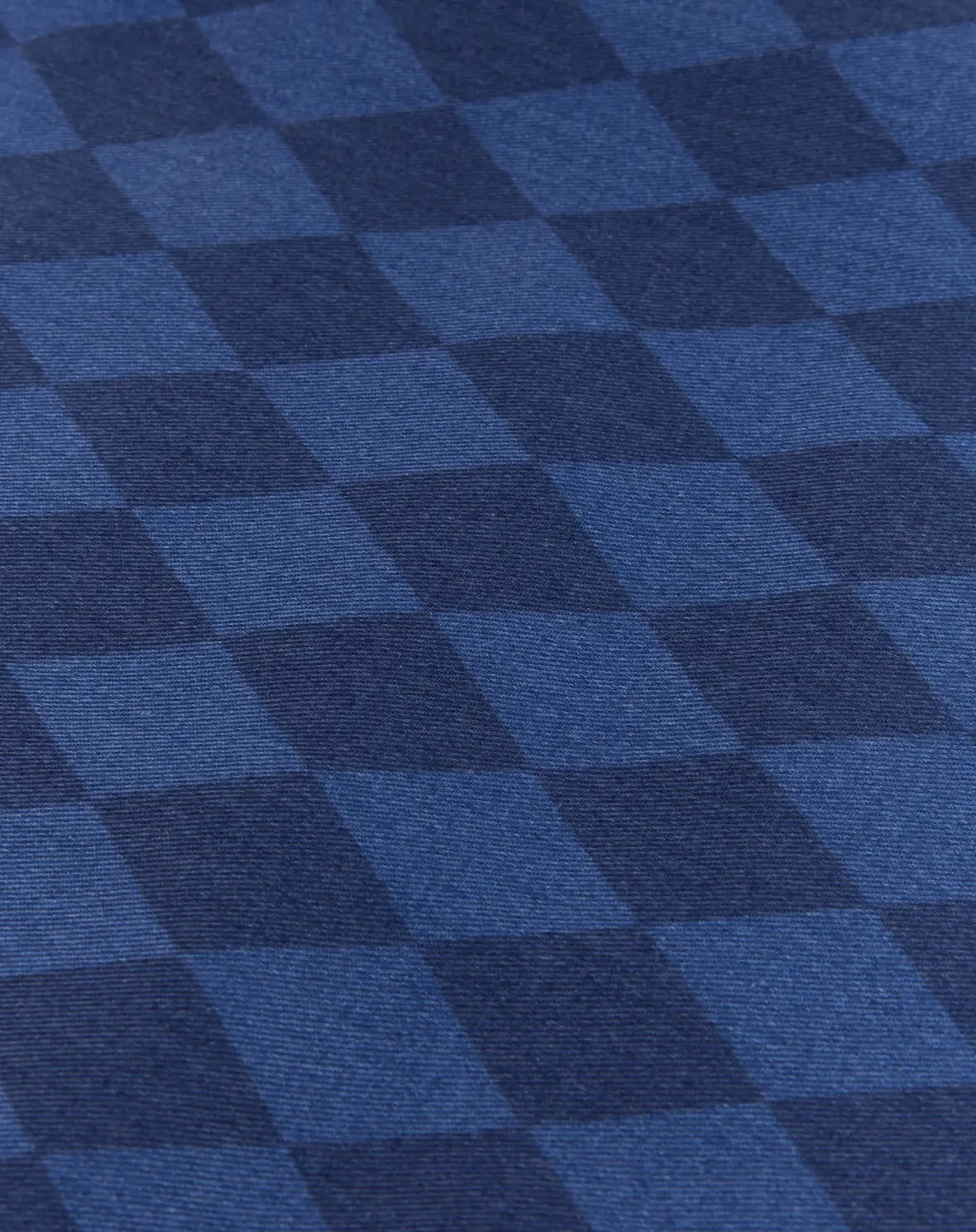 A close-up of a blue and navy checkered fabric pattern with a visible woven texture.