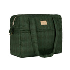 A dark green quilted puffer bag with dual shoulder straps and a small tan leather brand patch on the front, shown against a plain white background.
