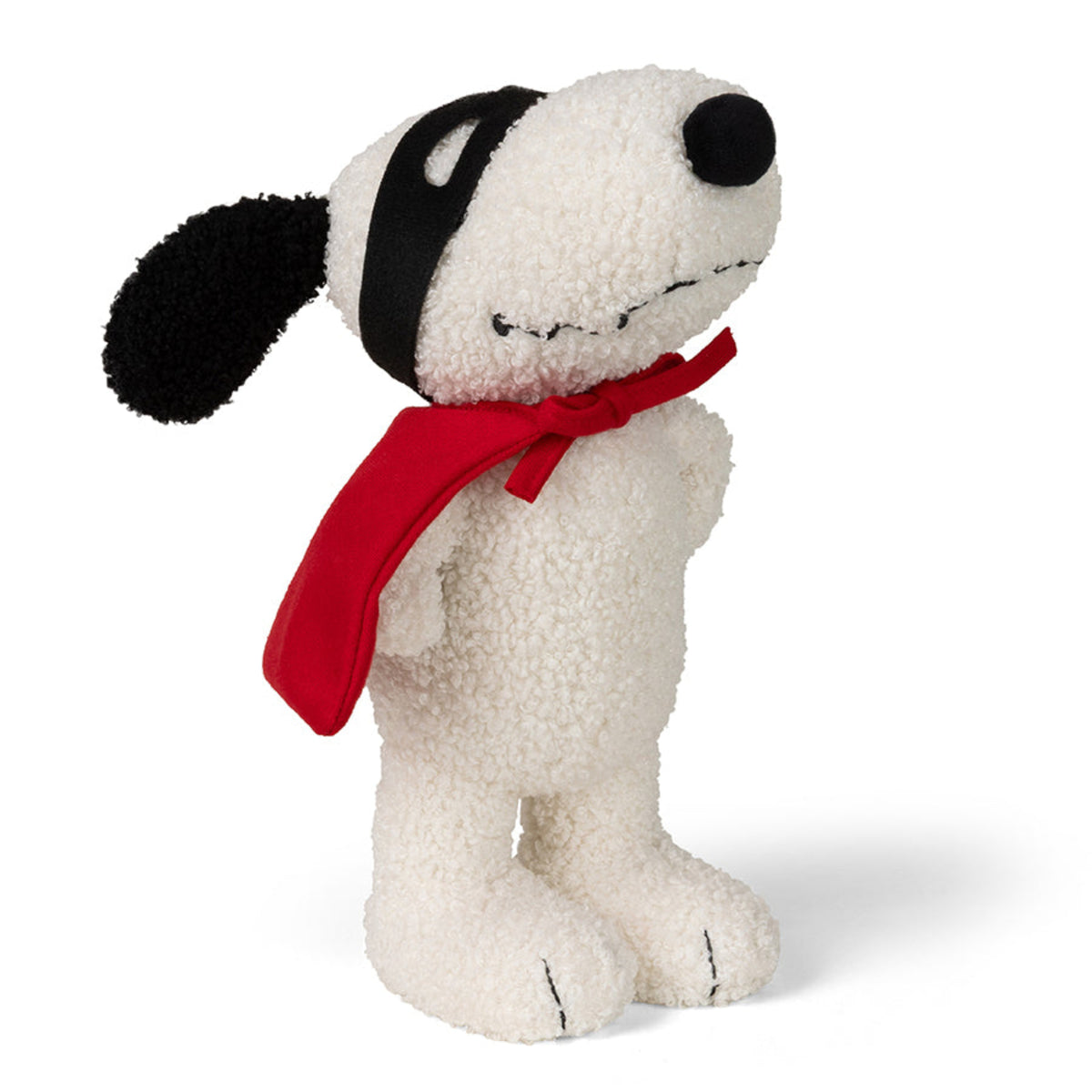 A plush dog toy styled like Snoopy, made from textured white bouclé fabric, wearing a black patch-over-ear headband and a bright red scarf, set against a plain white background.
