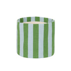 A cylindrical container or candle holder with a woven fabric cover featuring vertical stripes in green and light blue, with a light beige interior visible at the top, set against a plain white background.