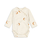 An off-white long-sleeve baby wrap bodysuit with an all-over print of orange crescent moons and tiny stars, displayed flat against a white background.